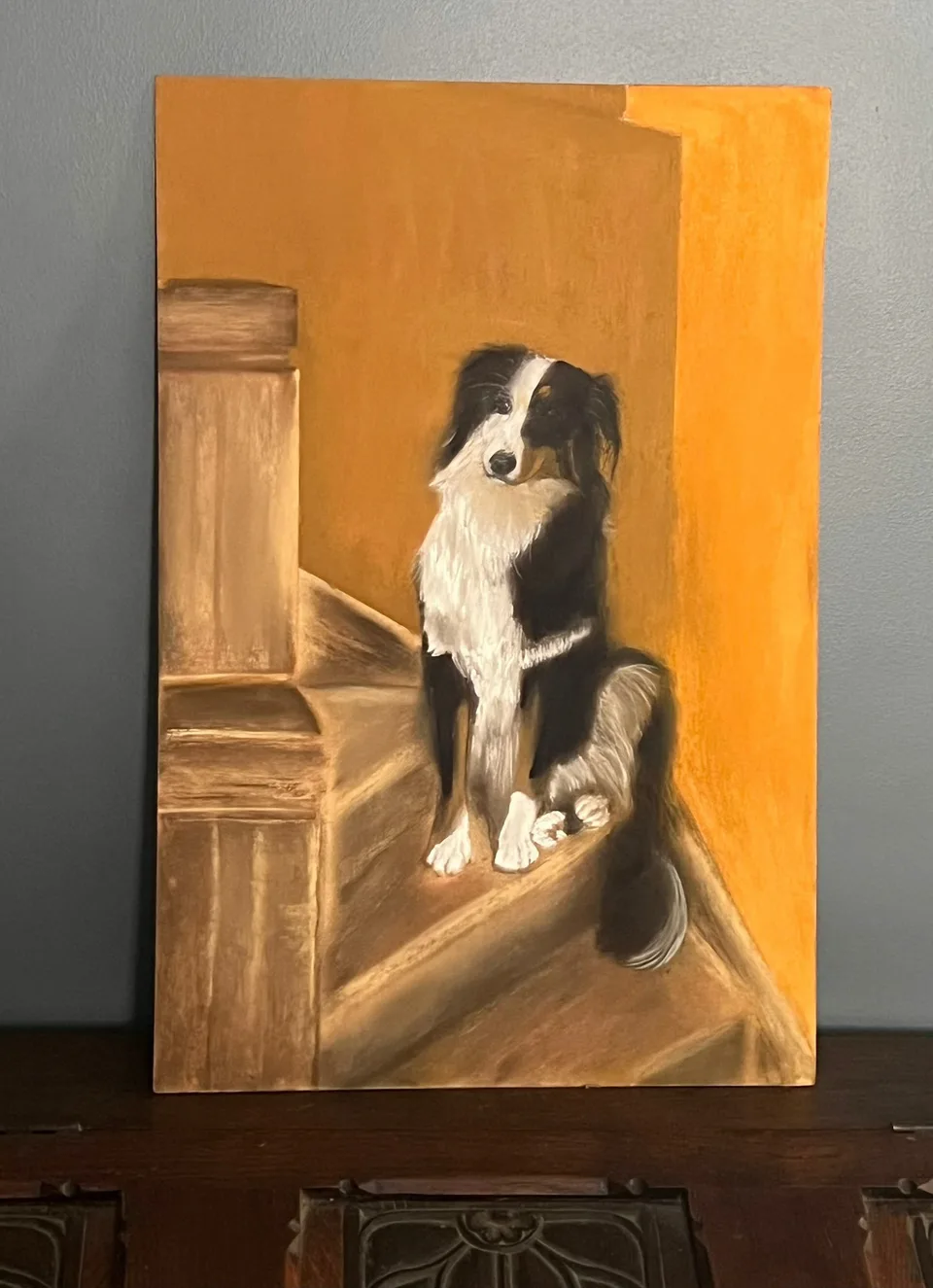 Painting: a dog sitting on a staircase against an ochre background